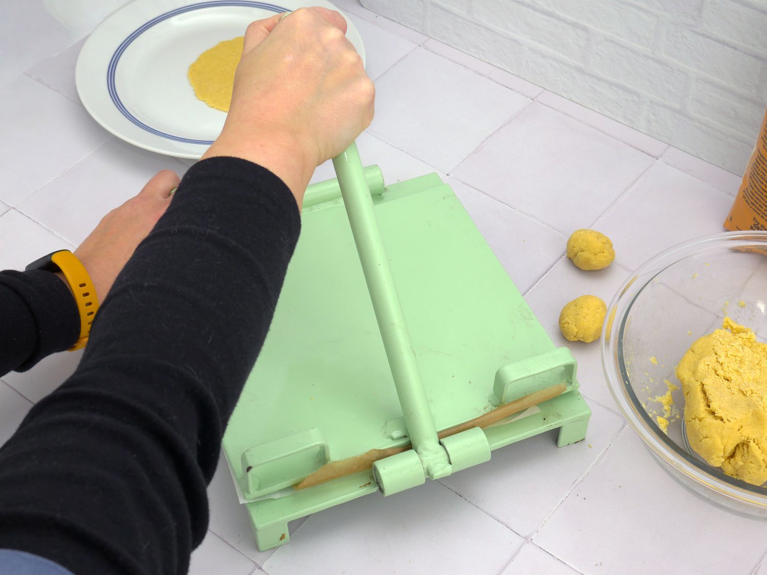 a person pressing tortillas