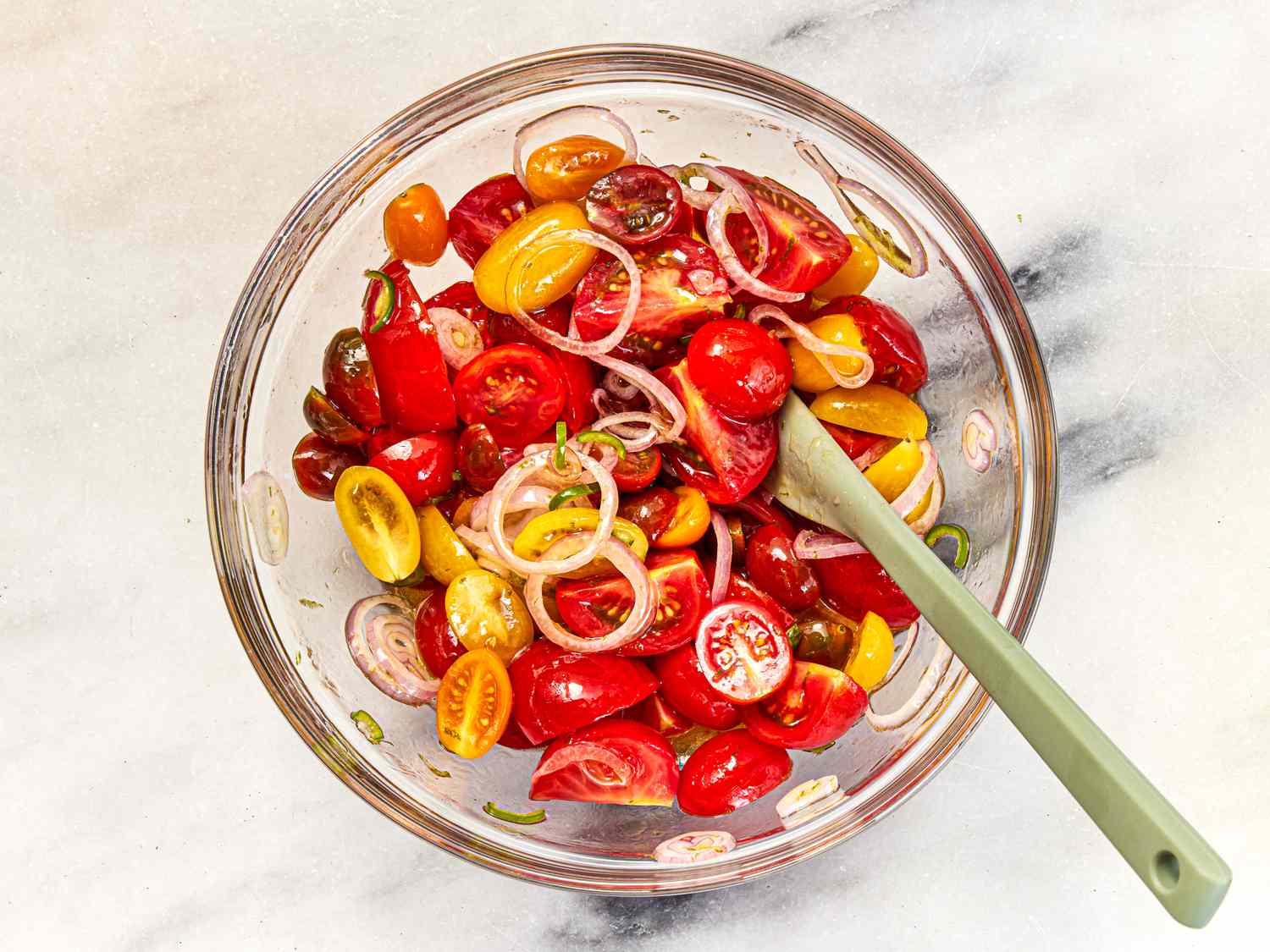 A bowl with cocktail and cherry tomatoes in shallot dressing