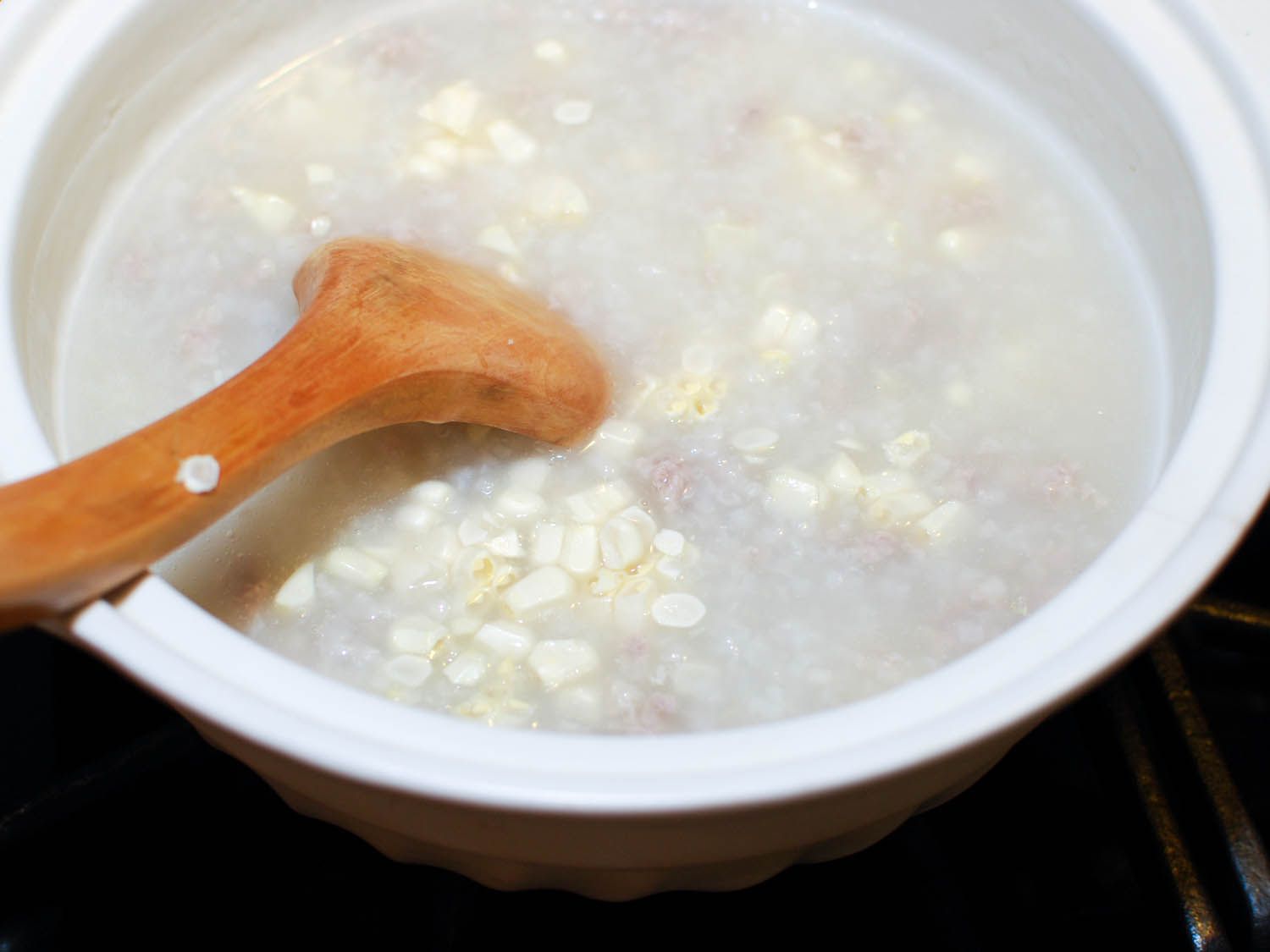 Adding corn to finish the congee. 