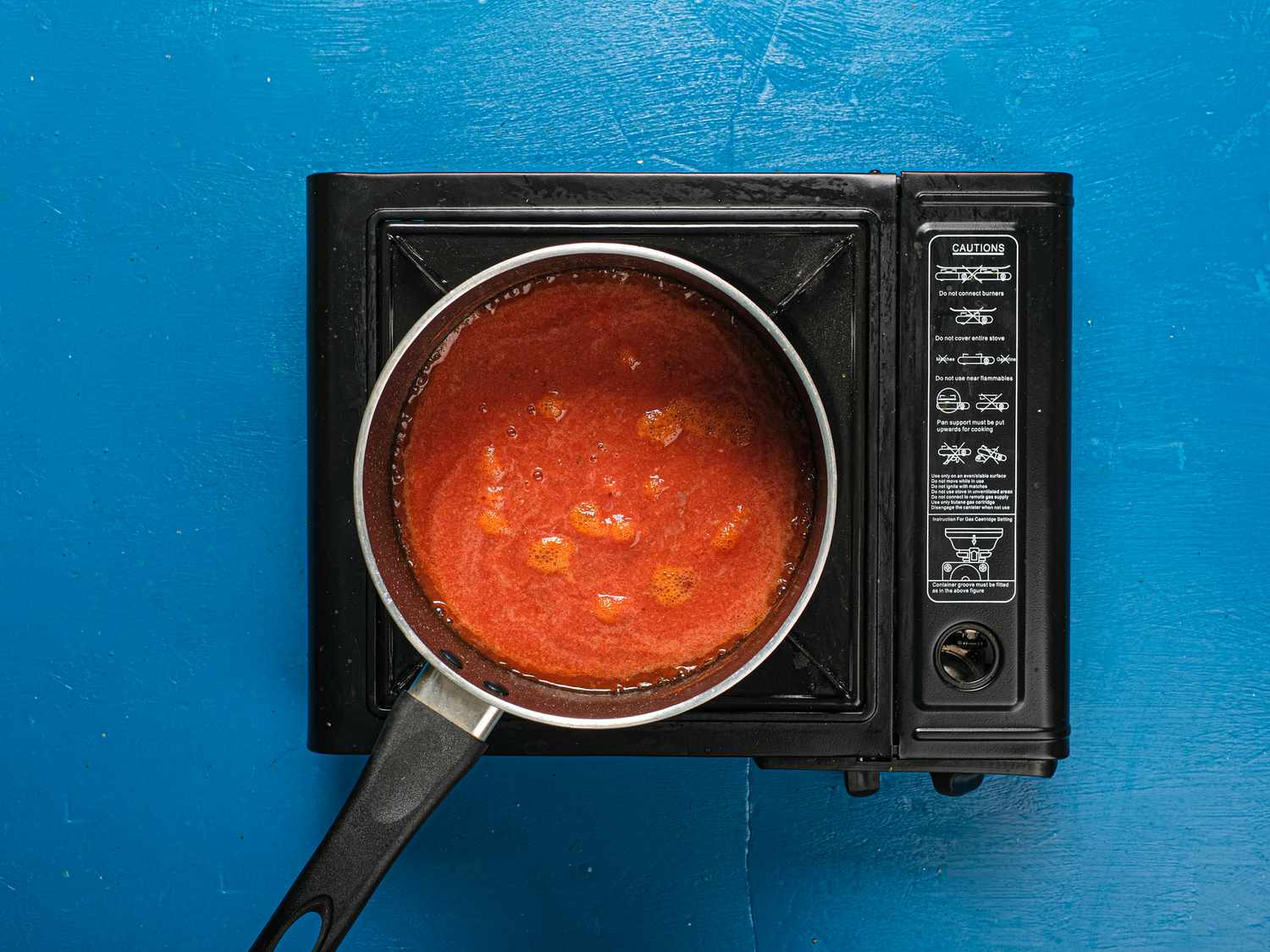Tomato puree added into pot on heat