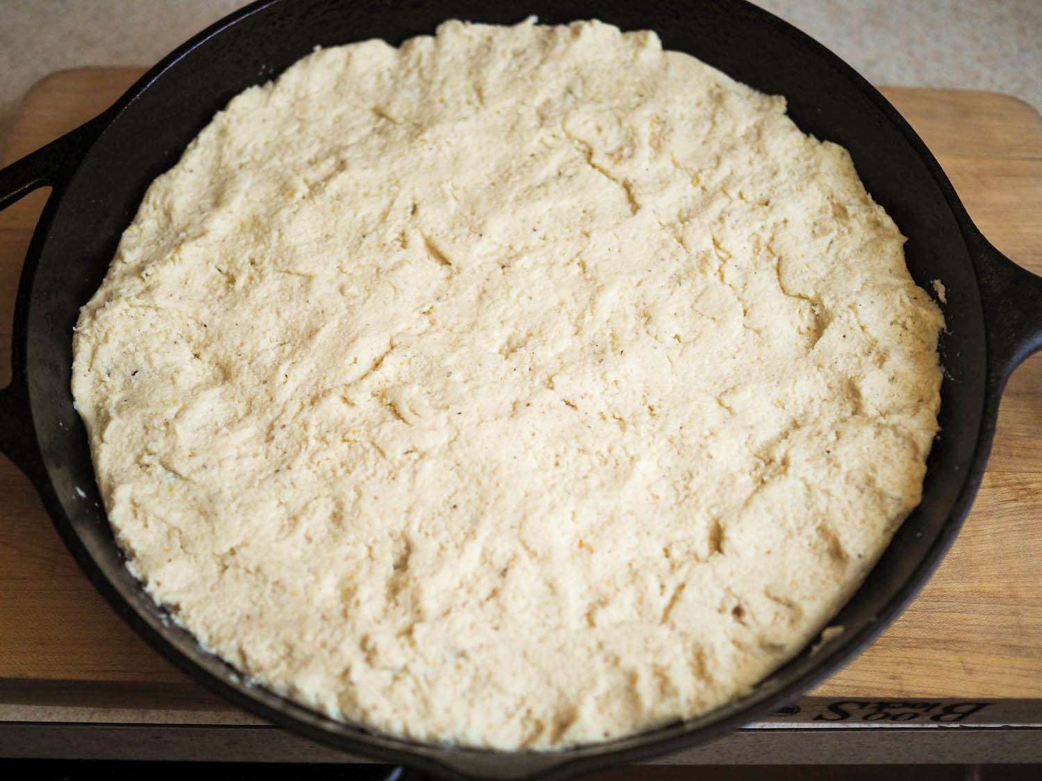 The filling has been completely covered with a top crust of masa. 