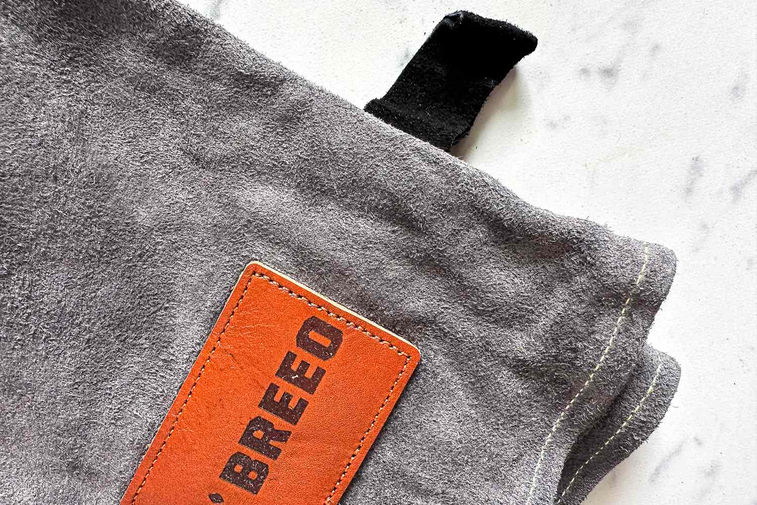 The brand name printed on a patch on the Breeo Fire Pit Gloves
