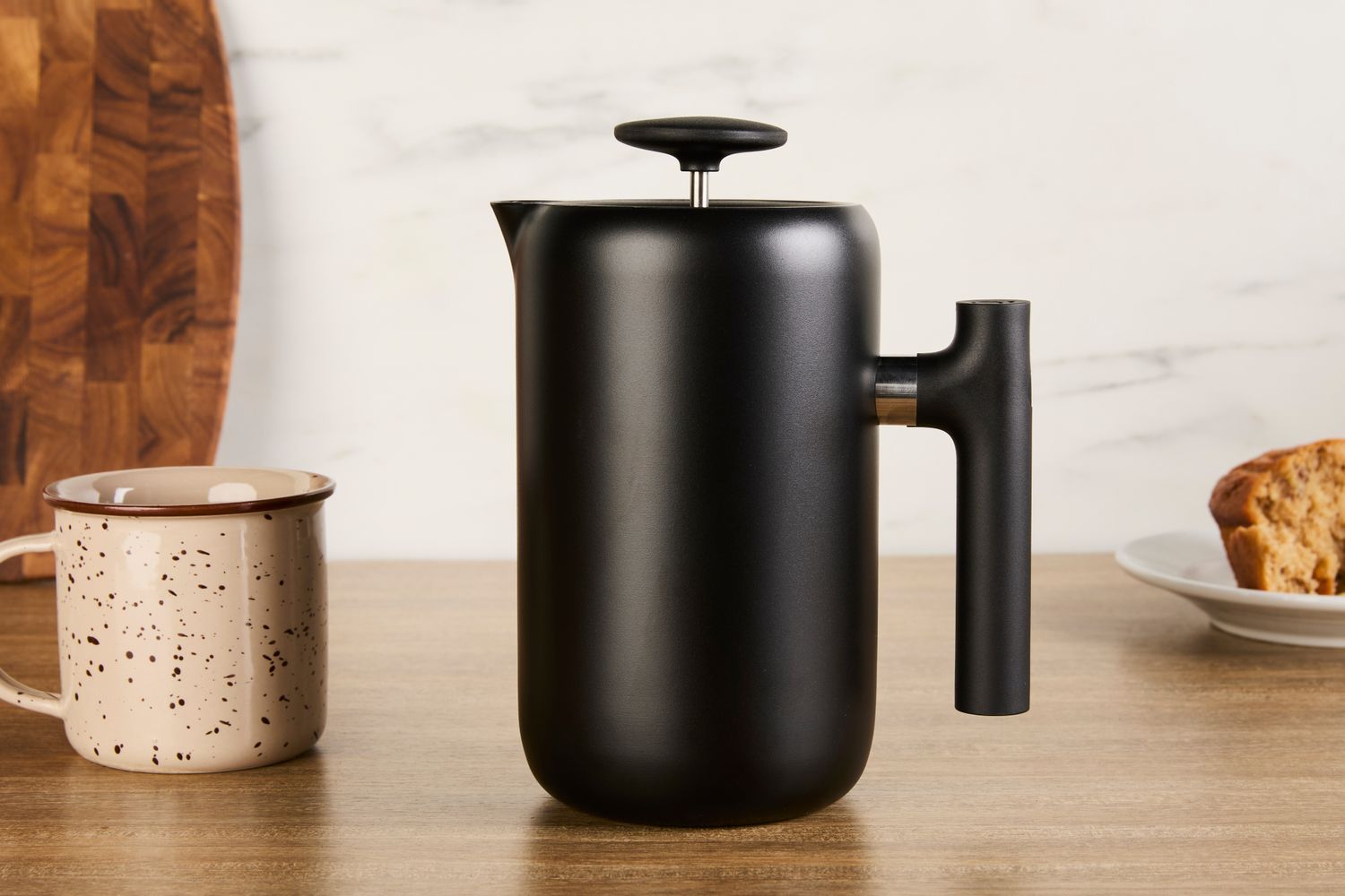 The Fellow French press kettle on a wooden countertop.