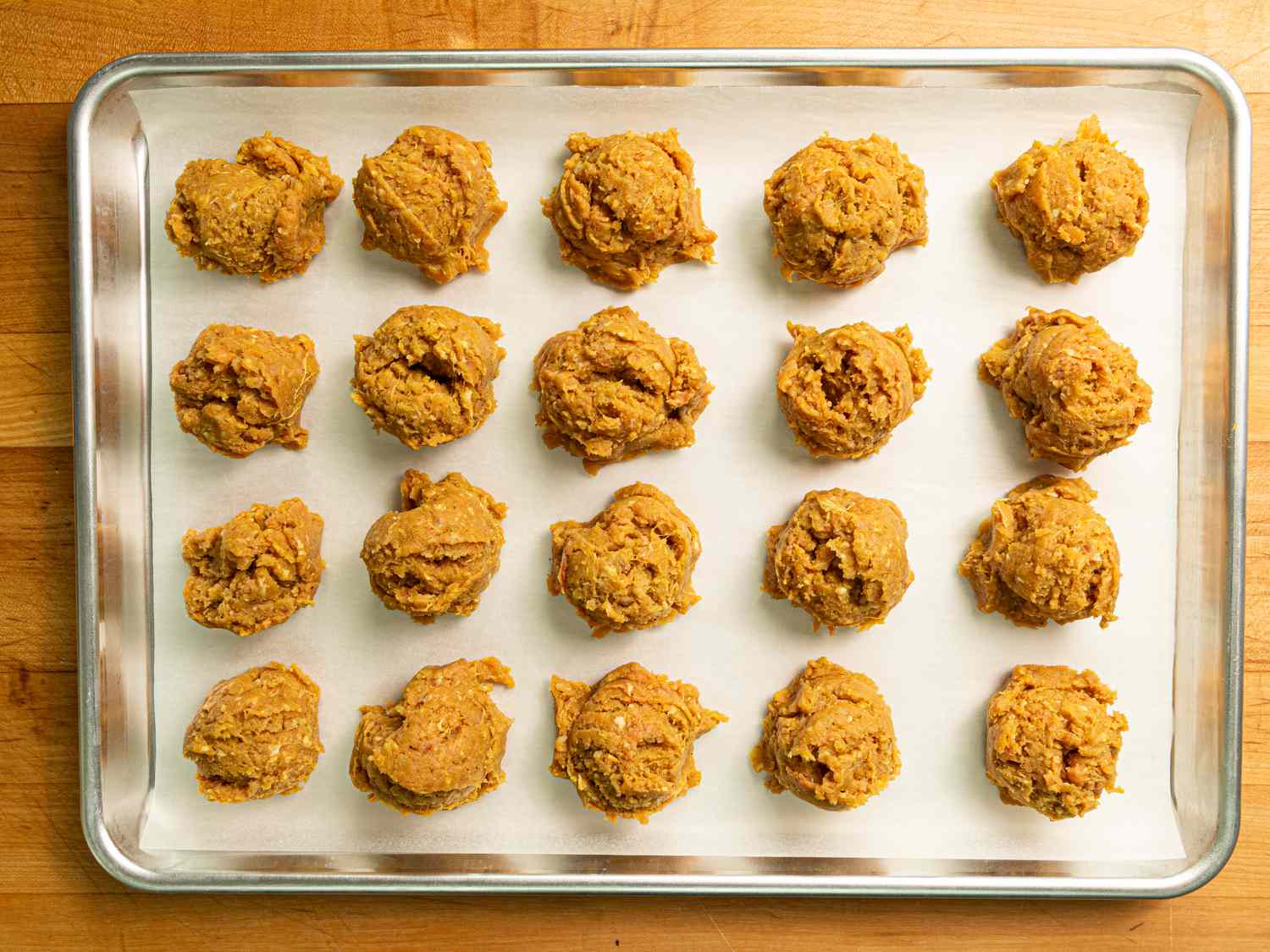 Overhead view of portioned mixture on a parchment lined baking sheet