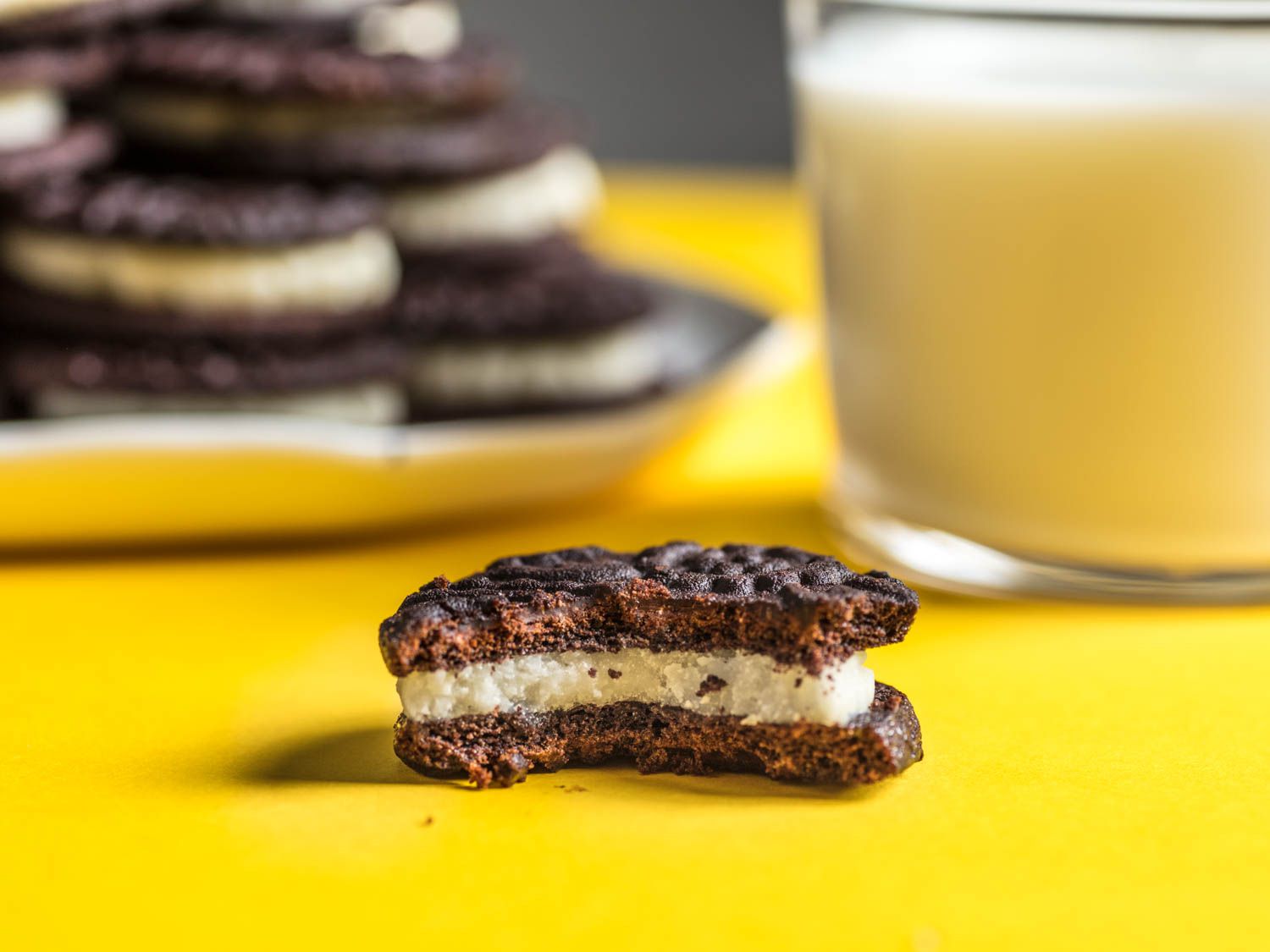 A half eaten homemade Oreo cookie, revealing its creme filling. 