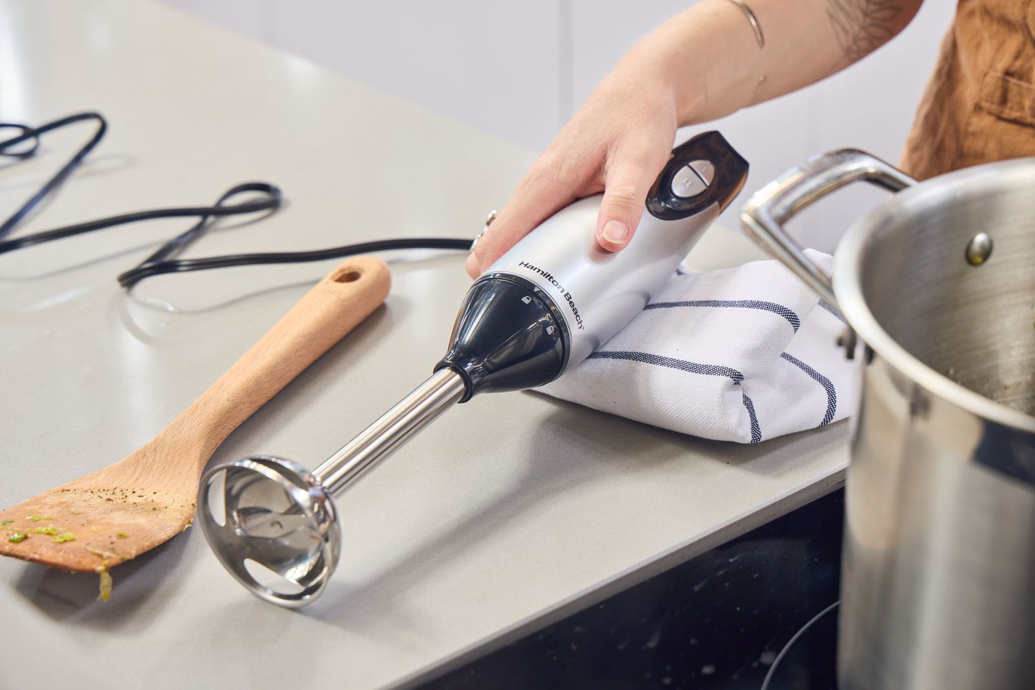 A person picks up the Hamilton Beach 2-Speed Hand Blender