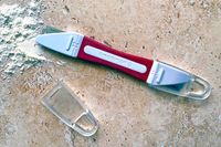 The Breadsmart bread lame on a countertop next to a pile of flour