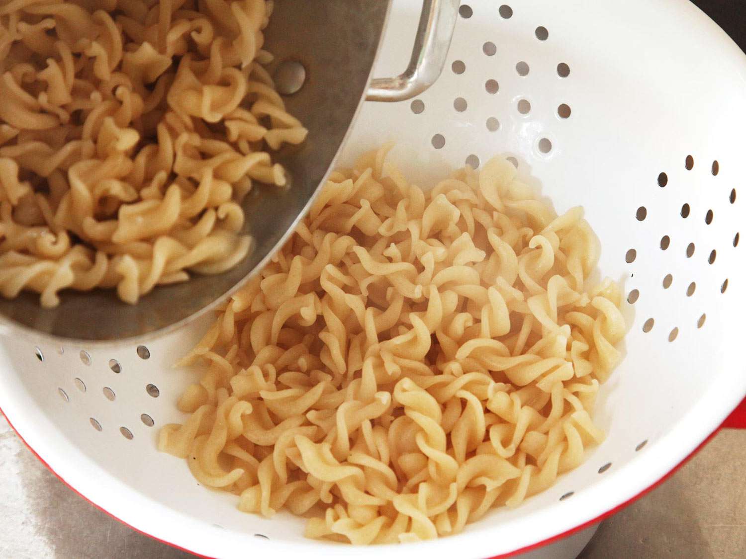 Draining cooked pasta in a colander.