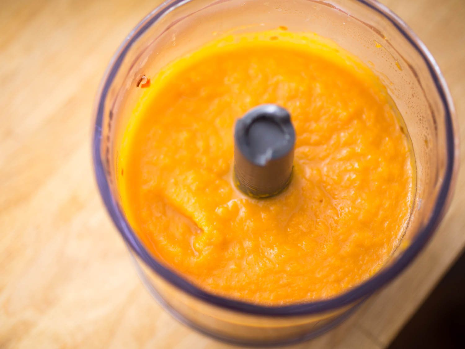 Overhead view of butternut squash purée in blender canister.