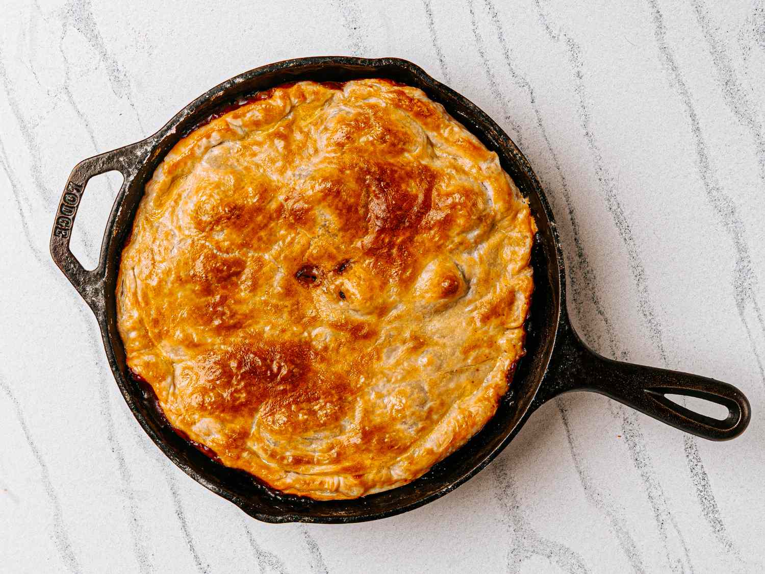 A cast iron skillet with beef bourguignon pot pie