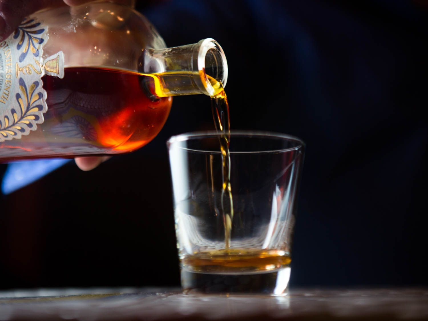 Amaro Nonino is poured from the bottle into a small glass. 