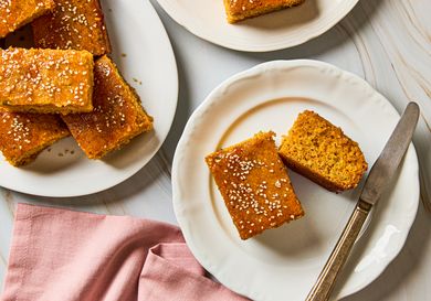 Gochujang scallion cornbread pieces served on plates topped with sesame seeds
