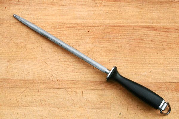 A honing steel resting on a cutting board.