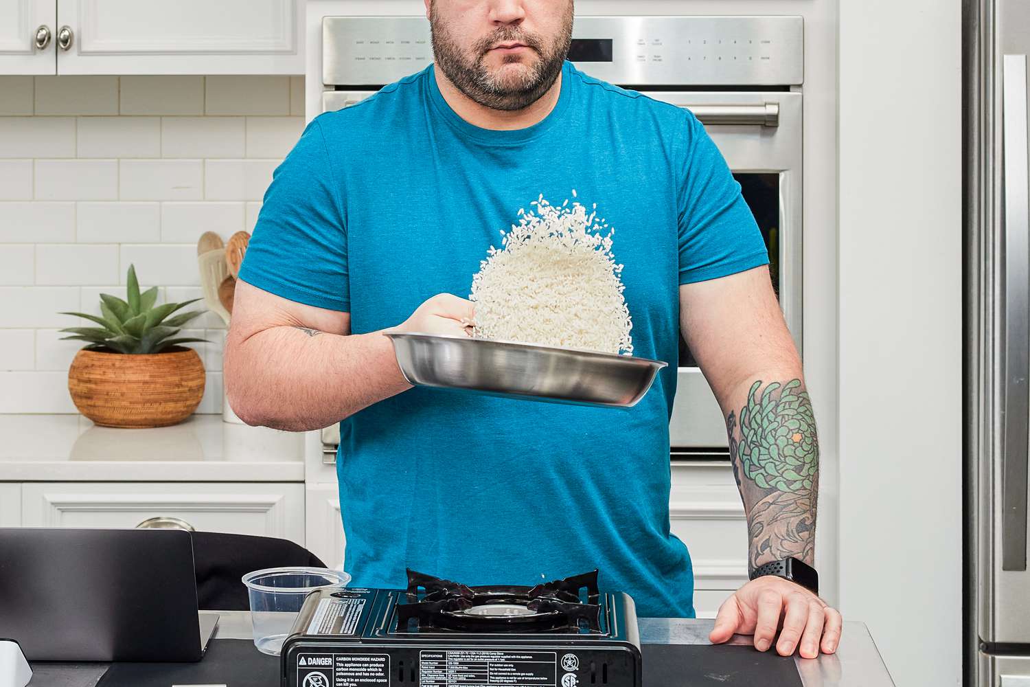 a person tossing food in a stainless steel skillet
