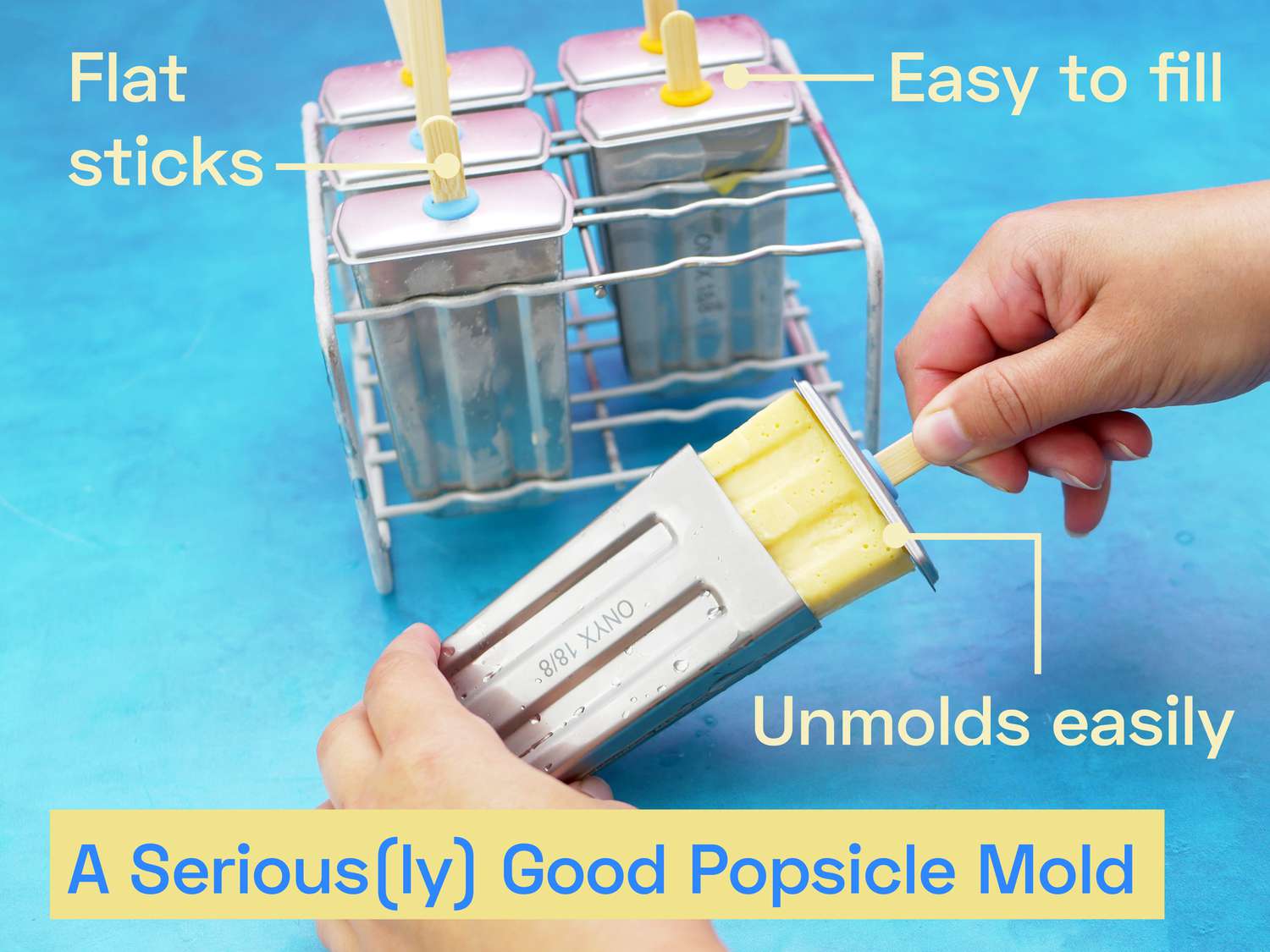 a hand removing a popsicle from the metal onyx mold