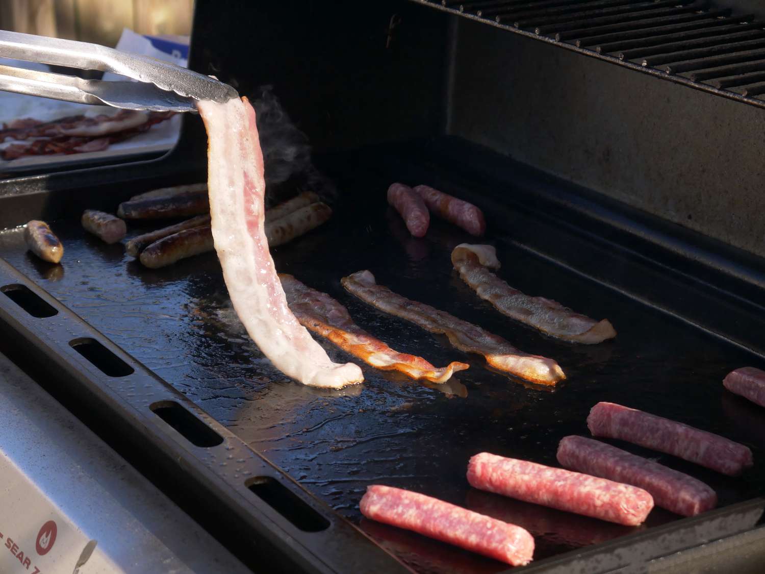 flipping bacon on the griddle