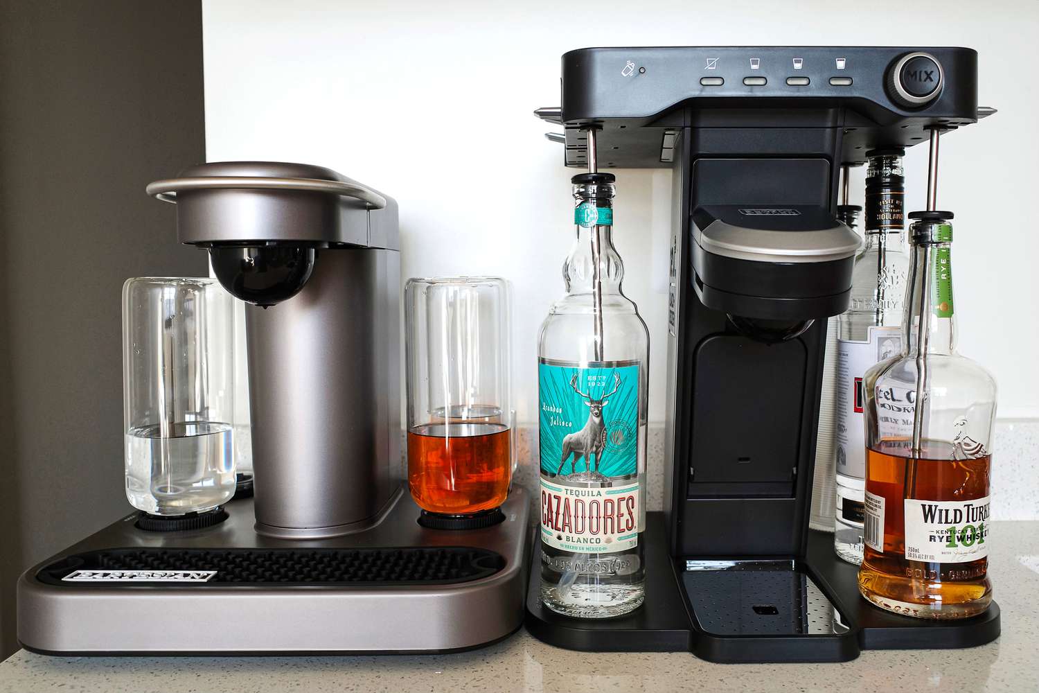 The Bartesian and Bev cocktail machines adjacent to each other on a kitchen counter.
