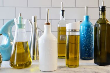 An assortment of olive oil dispensers on a marble counter