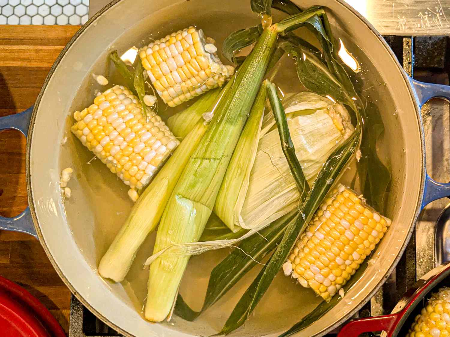 Overhead view of corn and corn husks boiling