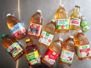 Various brands of apple juice bottles arranged on a metal surface