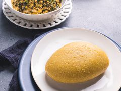 Eba plated next to a bowl of egusi soup