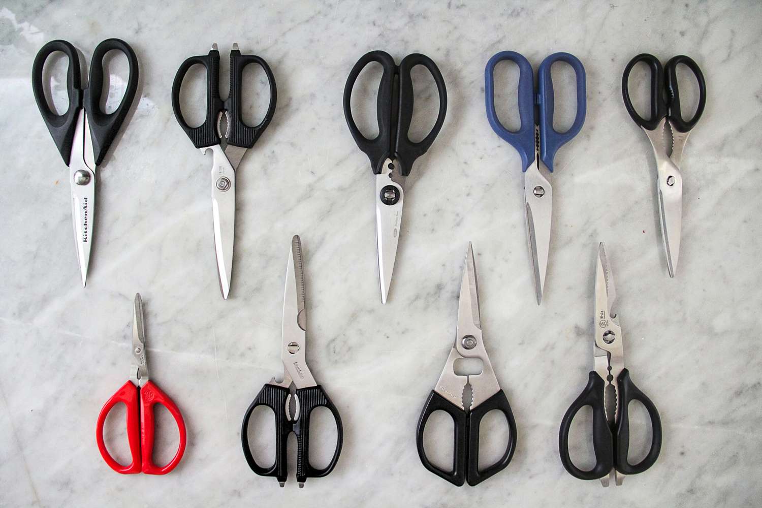 A selection of kitchen shears arranged on a flat surface