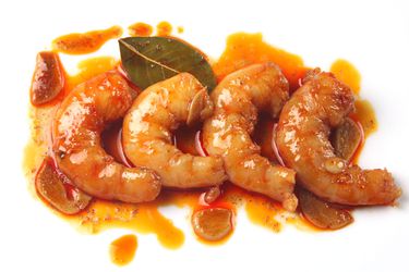 Closeup of Sous Vide Shrimp With Garlic, Sherry, and Smoked Paprika, served on a white plate.