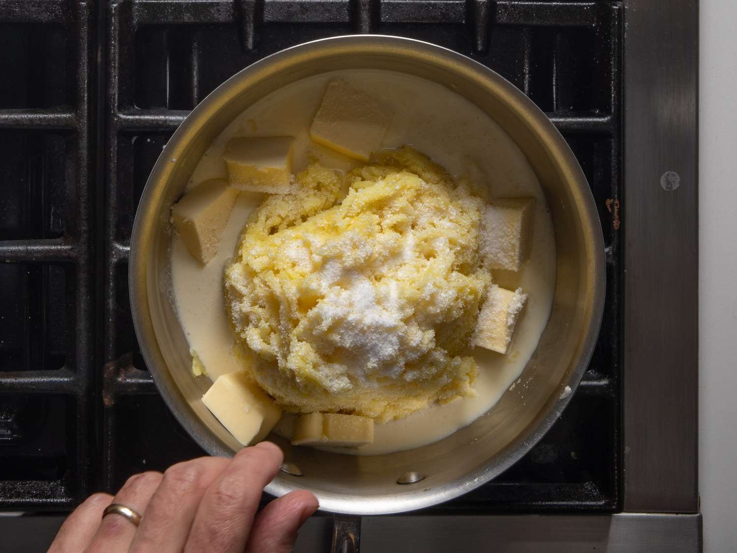Potoes, cream, and butter in the pot before mixing, with a generous amount of salt sprinkled on top.