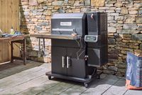 The Masterbuilt Gravity Series 1150 Digital Charcoal Grill and Smoker on a patio