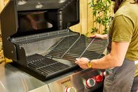 A person assembles the Weber Genesis E-325 Liquid Propane Gas Grill