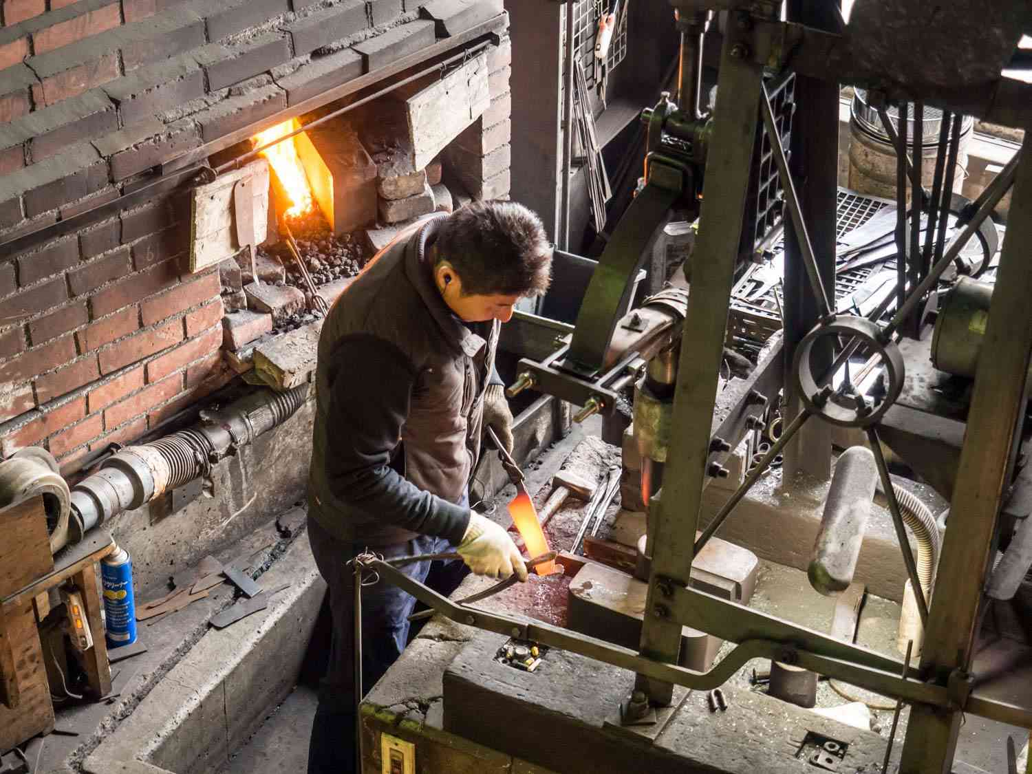 Yoshimi Kato, a Japanese bladesmith at work, heating a knife blank until it glows.