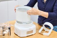 Two hands assembling the Cuisinart 1.5-Quart Ice Cream Maker