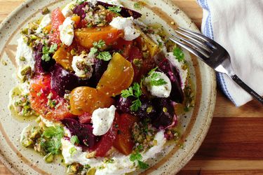 An overhead view of a colorful plate of beet and citrus salad with a pistachio dressing. 