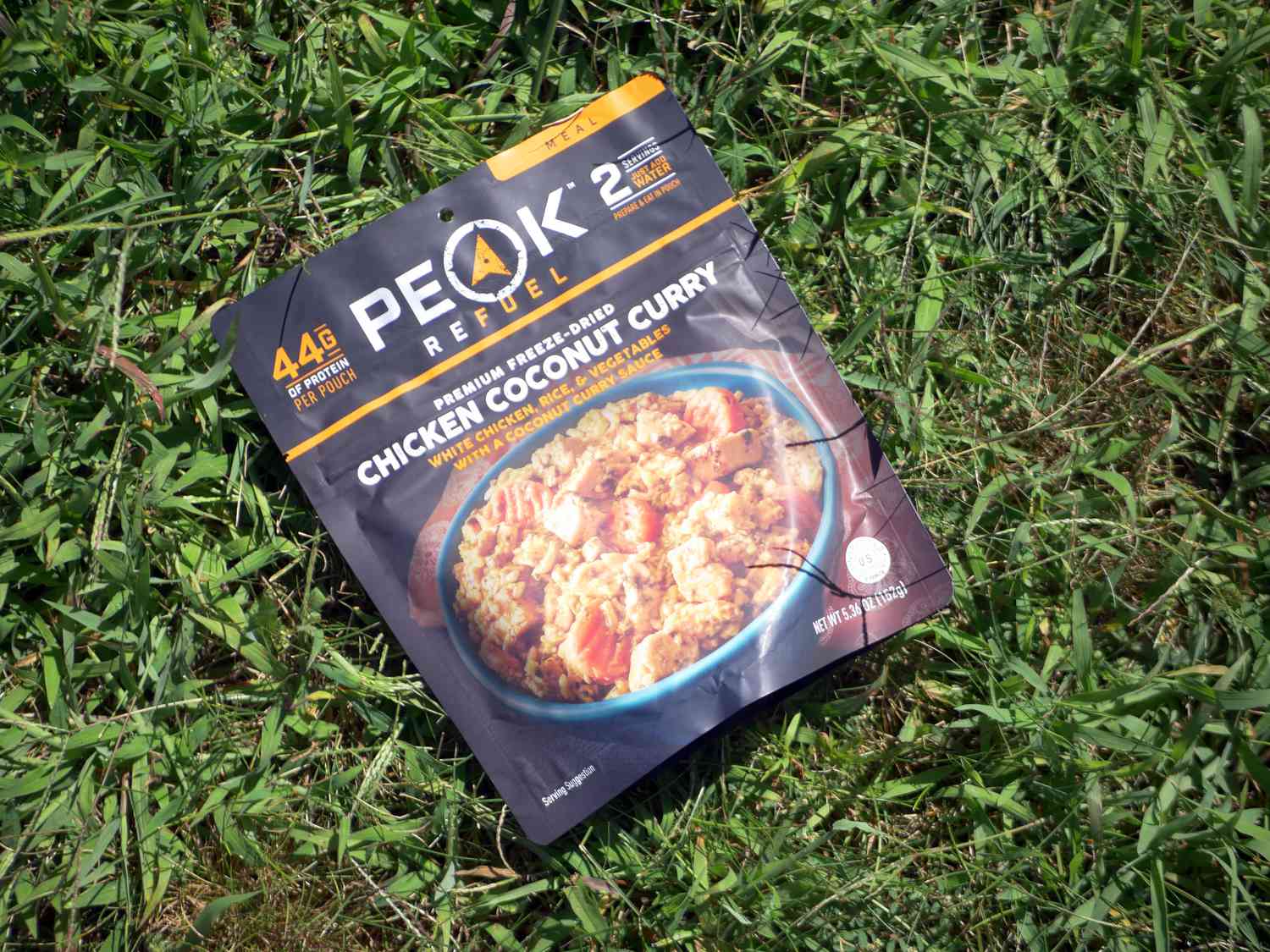 peak refuel chicken coconut curry packet on a grassy lawn