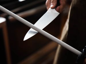 a knife being sharpened with a ceramic honing steel