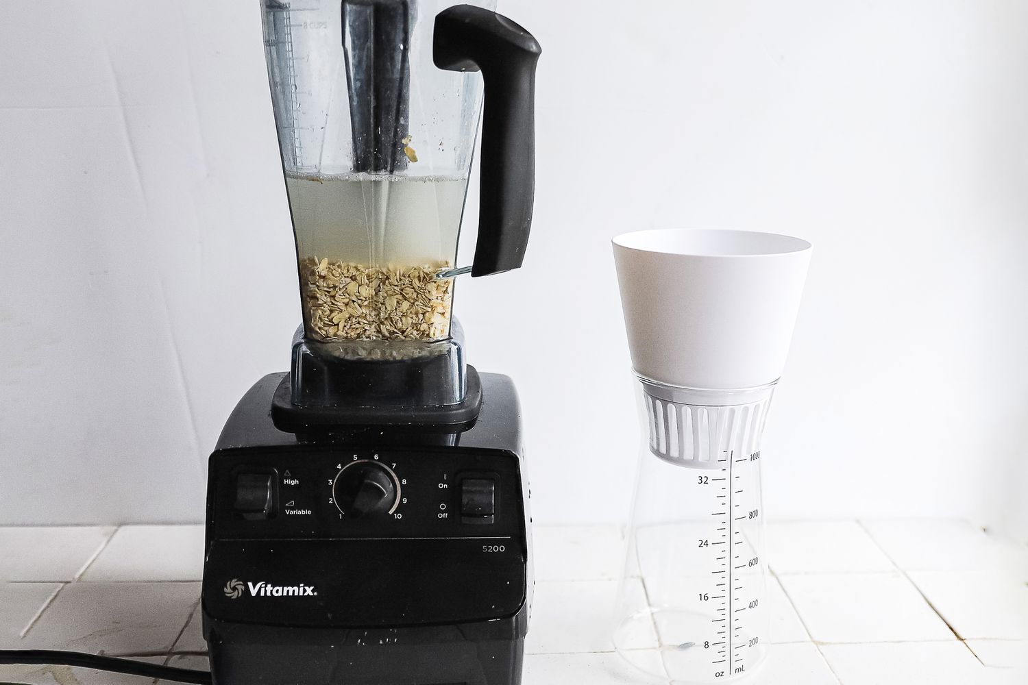 a blender with soaking nuts and the chefn next to it
