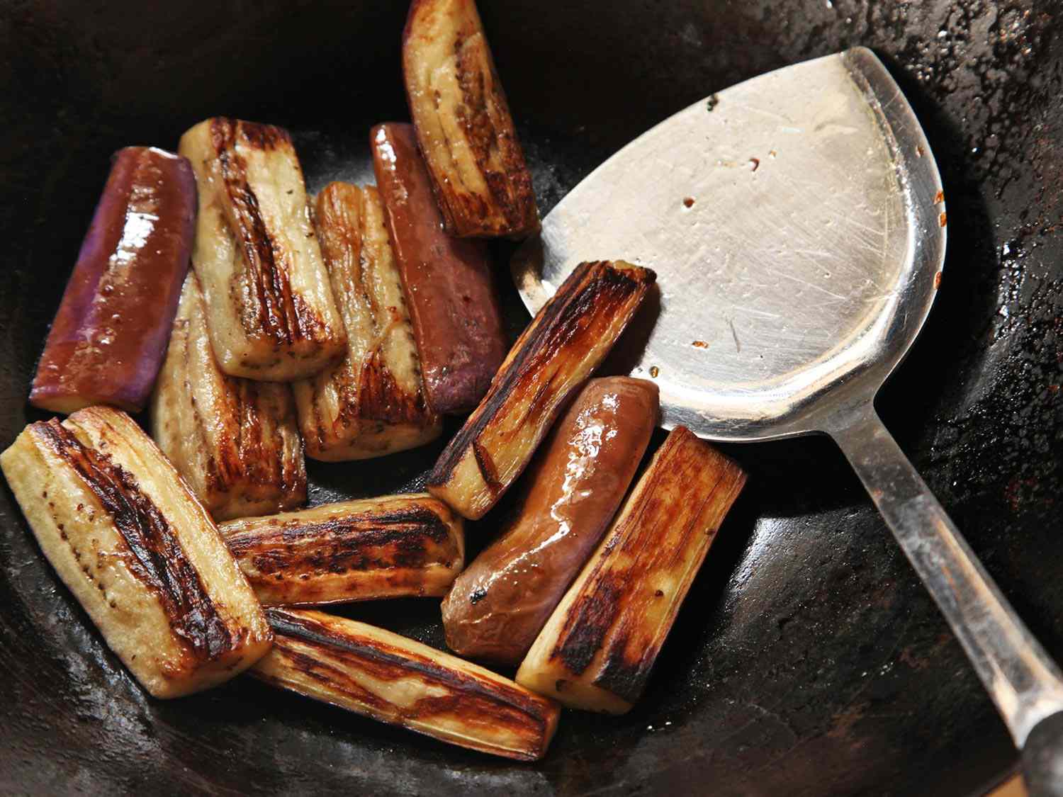 Eggplant is charred on all sides in a wok.