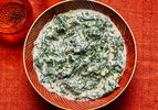 A bowl of creamed kale on a red tablecloth