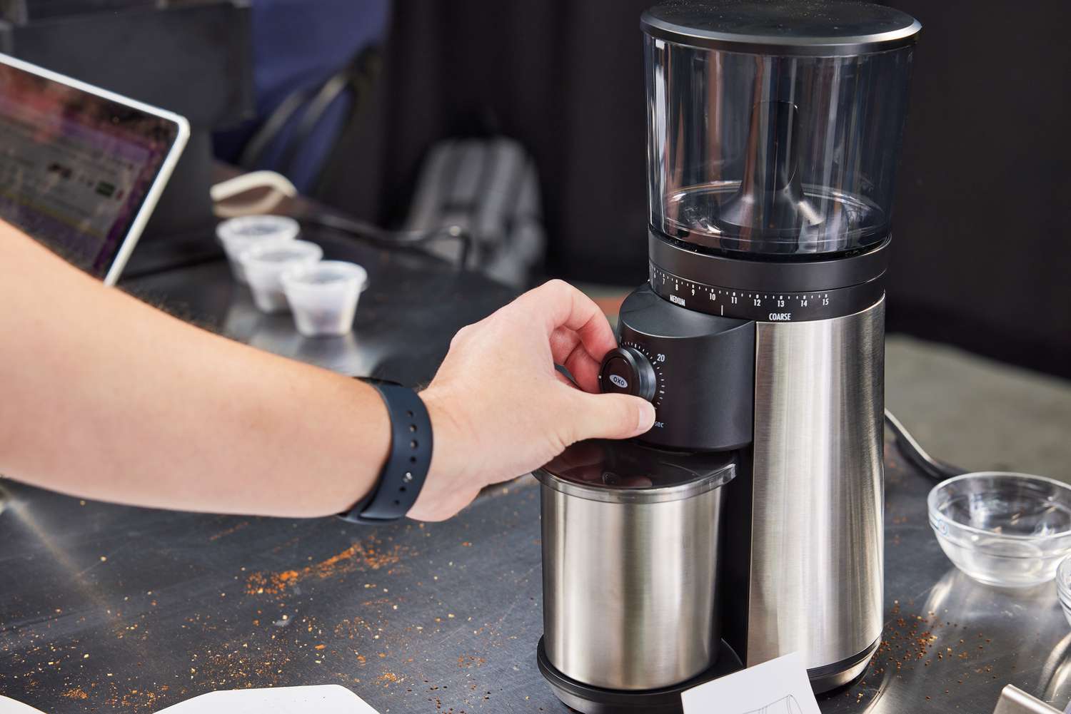 Person's hand cranking a setting on the OXO Brew Conical Burr Coffee Grinder