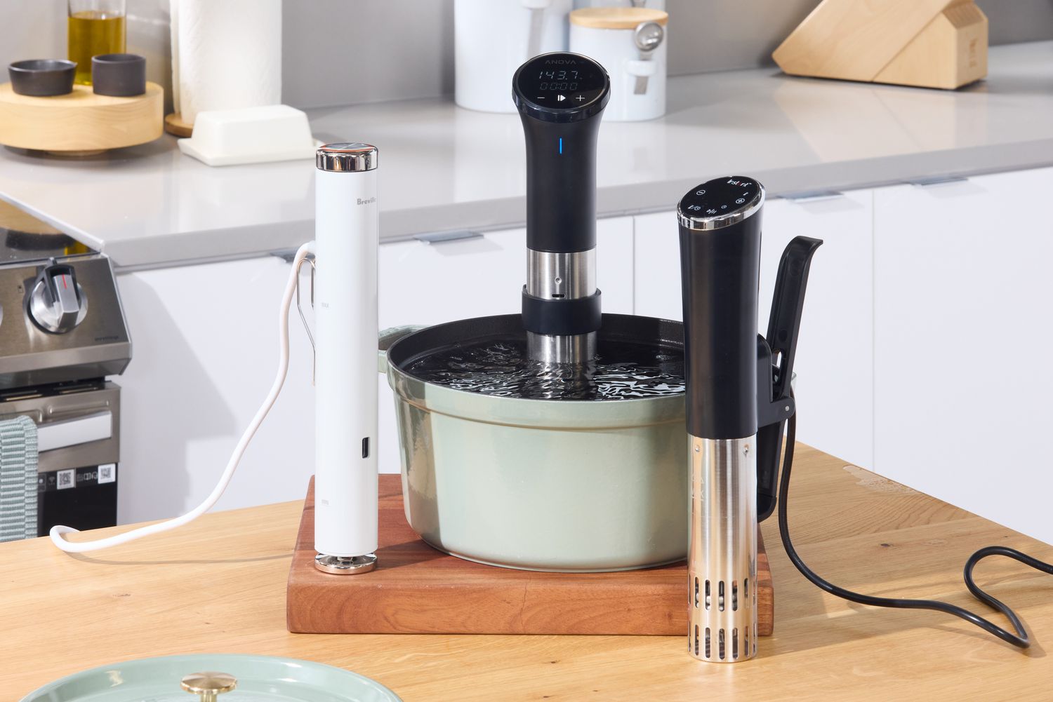Three sous vide machines on a kitchen countertop.