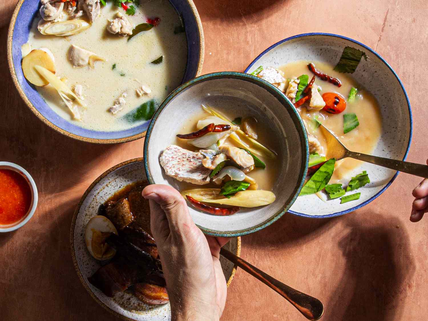 Someone getting a serving of Tom Yum Pla soup.