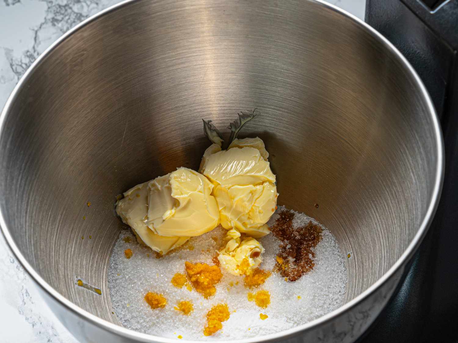 Butter sugar and other ingredients in a metal mixing bowl