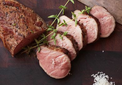 Sliced sous vide pork tenderloin cooked medium rare and seared to form browned exterior.