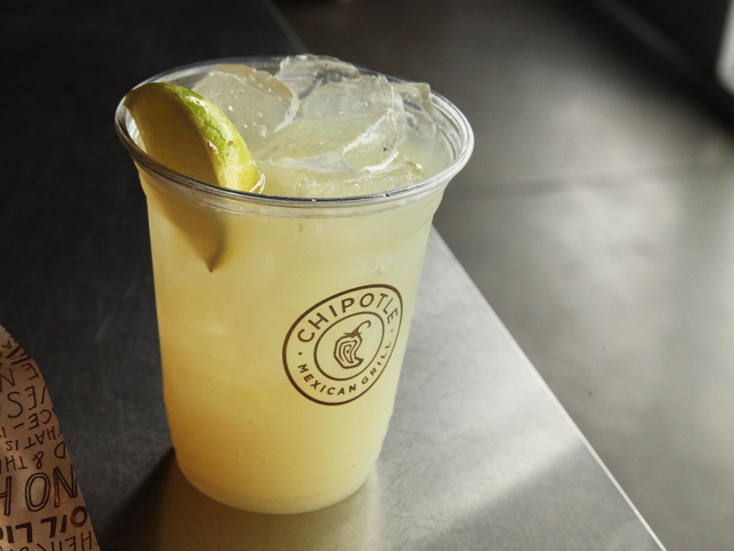 A margarita from Chipotle with a lime wedge in the cup 