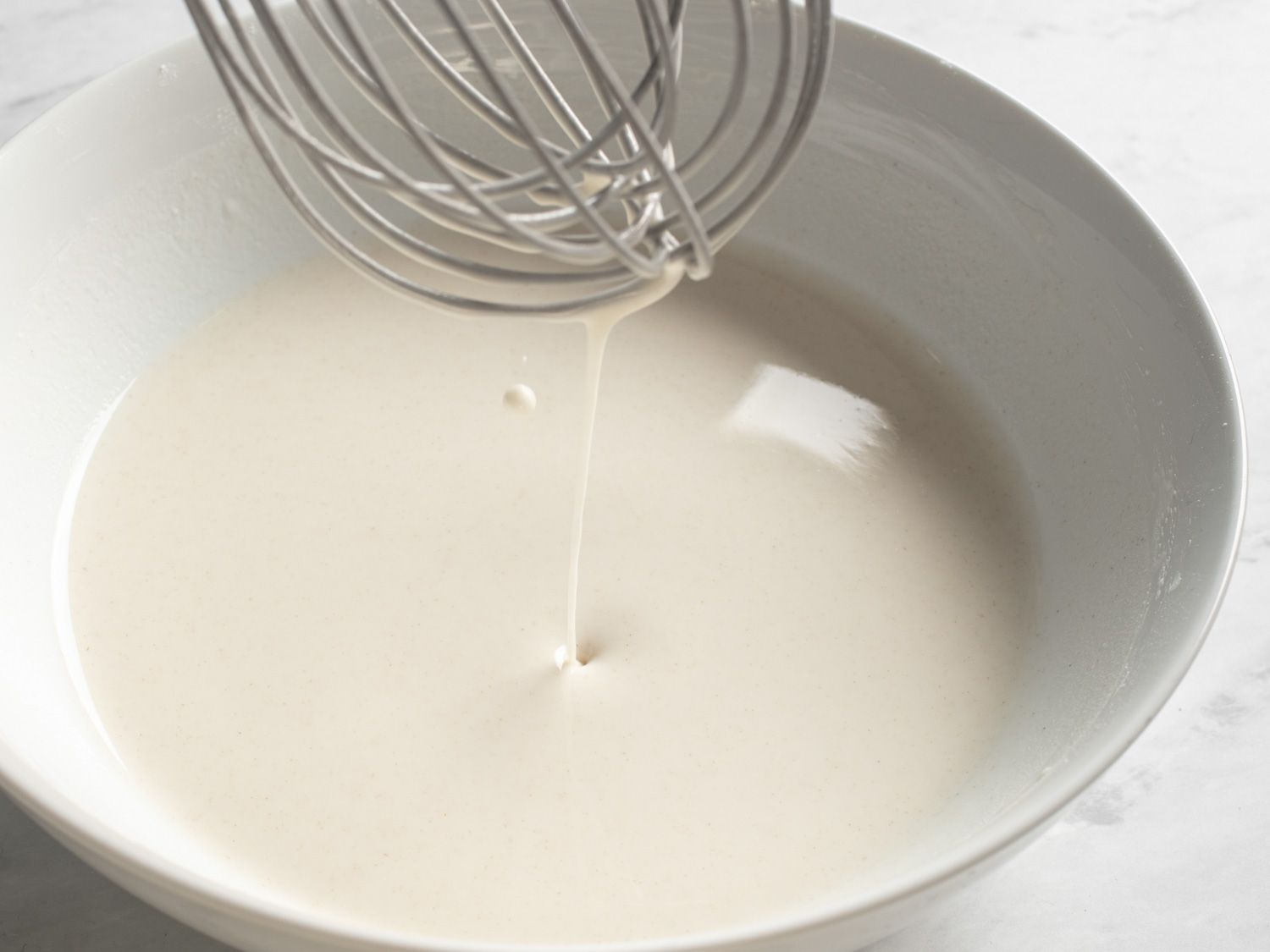 Whisking together a thin batter for vegan kung pao tofu