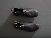 Black Blundstone boots on a grey floor.