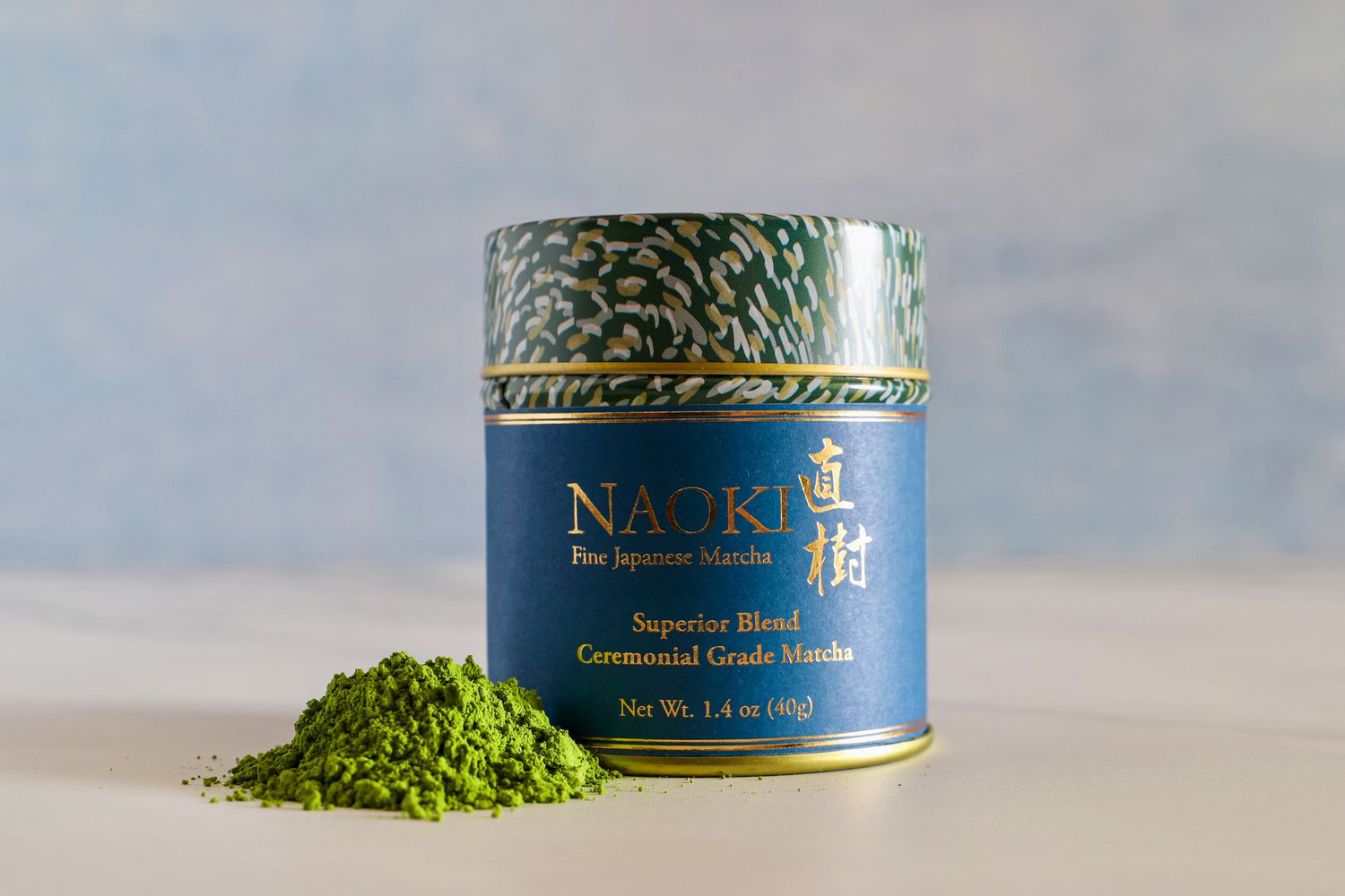 A container of Naoki Matcha Superior Ceremonial Blend next a pile of the powder