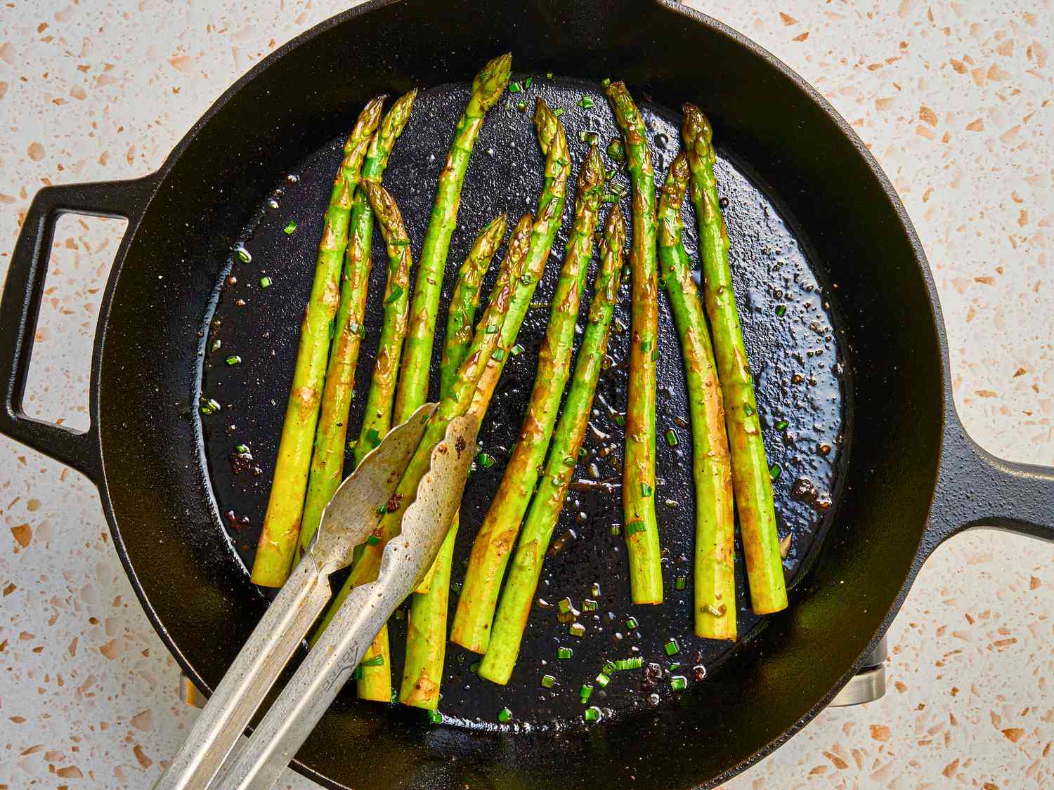 Overhead view of tossing asparagus with lemon