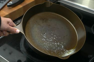 hand swirling melted butter in skillet
