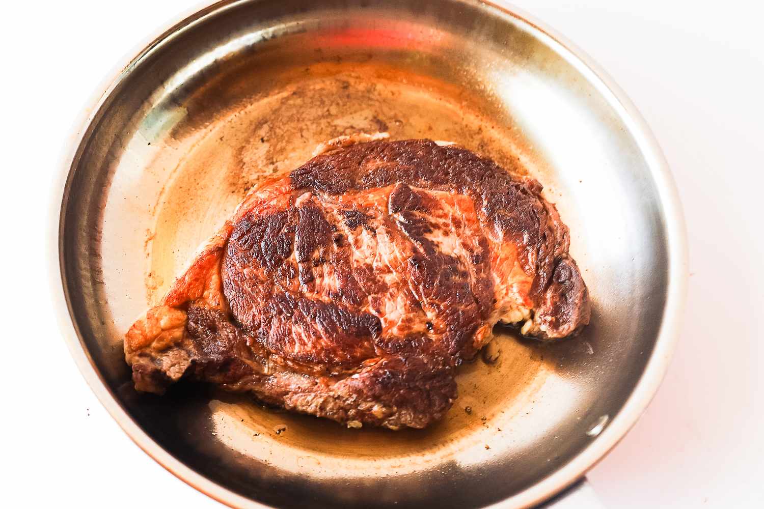 A cooked steak in a frying pan